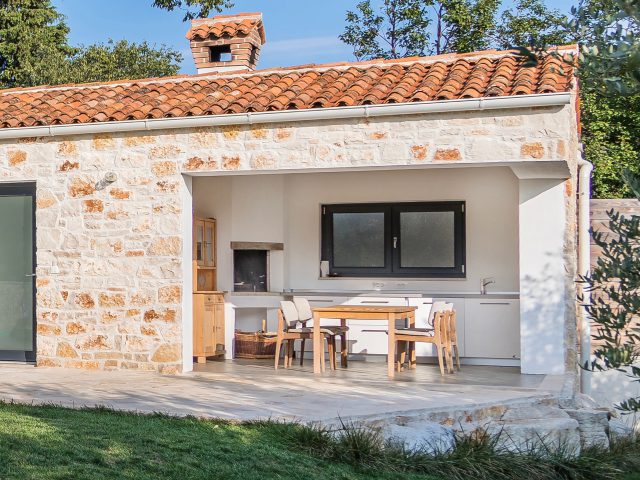 outside kitchen with fireplace surrounded by olive trees