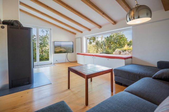 living room with fireplace and view to garden in mediterranean farmers house